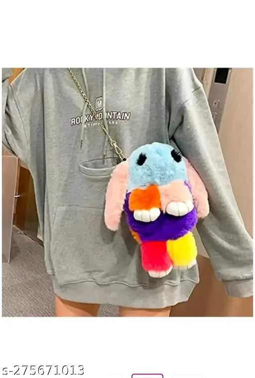 Vibrant, multi-colored stuffed rabbit keychain on gray hoodie
