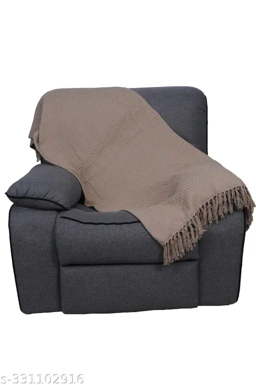 A jumbo size textile throw blanket with fringe, in neutral coloring