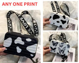 Small, black and white patterned shoulder strap handbag with a handle