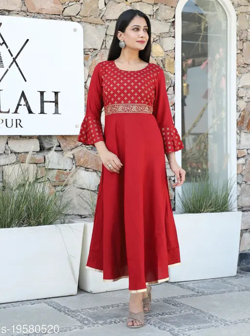Red kameez with embroidery on the bodice and long sleeves, standing outside a building