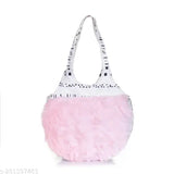 A fuzzy pink shoulder bag with white pom poms, designed for girls and women