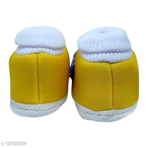 Yellow cotton knitted baby booties with ruffled cuffs and flat soles