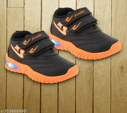 Black and orange kids' casual sports shoes with light-up accents, velcro closures, and a vibrant design