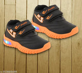 Black and orange kids' casual sports shoes with light-up accents, velcro closures, and a vibrant design