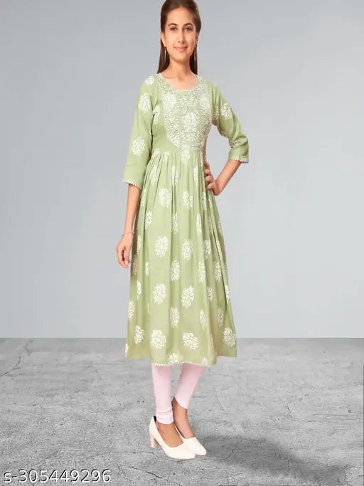Green cotton Muhuratam Kids Floral Round Kurtis with three-quarter sleeves, printed net pattern, for 9-10, 10-11, or 15-16 years old. Indian kids clothing on display rack