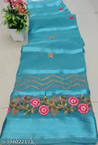 A long, teal blue cloth with gold sequin trim, and a few flowers sewn onto it