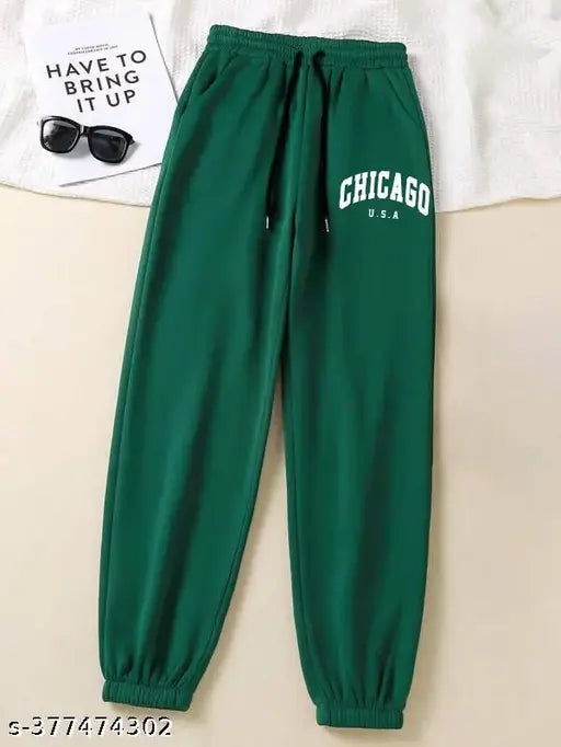 The image shows a pair of green stretchy jogging pants with a slim fit design. It's part of casual women's wear, suitable for summer or winter seasons. The straight and relaxed fit style suggests comfort and ease of movement