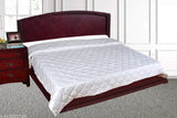 Diamond white quilt on a bed, possibly with a wooden frame and headboard