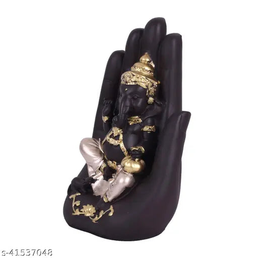 Black statue of Lord Ganesha with golden accents, intricate detailing, seated in a lotus pose