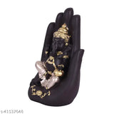 Black statue of Lord Ganesha with golden accents, intricate detailing, seated in a lotus pose