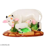 Marble look poly resin Kamdhenu cow & calf statue, VIDHAYA ARTS. Royal-feel decorative pooja murti for drawing/living room or pooja room. Made with fine grade marble powder, easily cleanable. Size: 13cmL x 8cmW x 9cmH, weight: 215gm. Origin: India