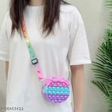 The image displays a brightly colored, playful sling bag with a pop-it feature and a pink bubble design. It has a silicone texture, resembling a fidget toy, which is often used for stress relief. The bag appears to be designed for children, given its youthful appearance and vibrant color scheme. It features multiple pouches and seems to have a coin purse function. The bag is designed with a shoulder strap for easy carrying and has a sturdy closure mechanism