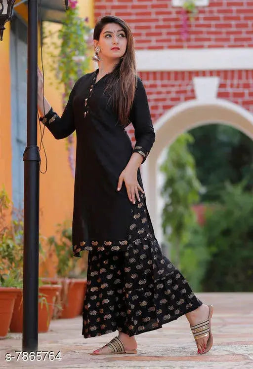 Black rayon kurta with sharara bottom, woman standing outside