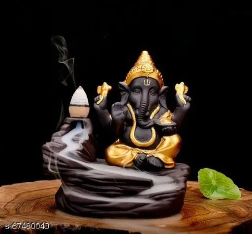 Handcrafted poly resin Ganesha smoke backflow incense burner, 9cm x 10cm x 8cm. Indoor decorative art piece featuring a meditating Ganesha by waterfall with reversed smokey effect from included 10 incense cones. Ideal for spiritual homes or as a unique gift. Handmade in India