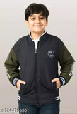 A young boy smiling at the camera, wearing a casual black jacket with white trim and brand logo