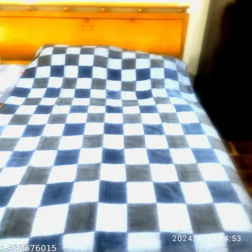 Checkered pattern, possibly cotton or flannel, covering a bed