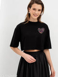 Trendy pink heart print black cotton crop tops with three-quarter sleeves and crew neck, loose fit for women & girls. Ideal for casual summer wear or workouts." (119 characters)