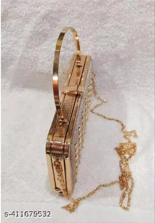 Golden clutch with a gold chain, adorned with a small figurine, featuring a metallic lock