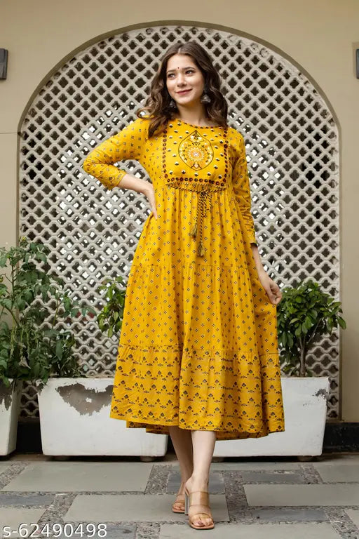 Mustard yellow sari with a flared bottom and a short sleeve length, posed on woman outdoors
