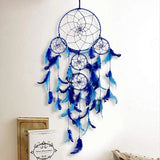 Handcrafted dream catcher wall art. Decorative tapestry with turquoise fringe, feather detailing, and attached to a white background