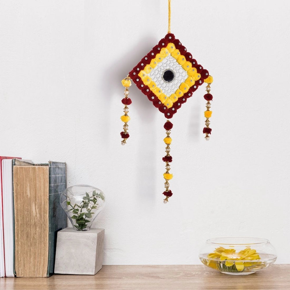 Colorful handmade wall art with a red tassel
