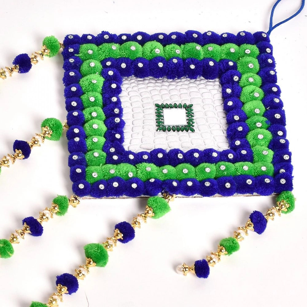 Handmade wall art with pompoms, navy blue background and green accents