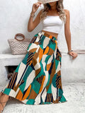 A high waist, pleated maxi skirt in colorful print on a woman standing