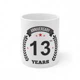 White ceramic coffee mug with printed anniversary message and star symbol