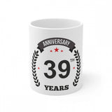 A white ceramic coffee mug with printed anniversary design and "39" years in black text