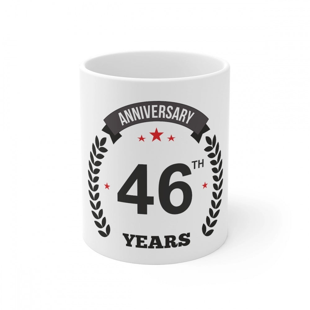 White ceramic mug celebrating 46th anniversary with printed text and laurel wreath border