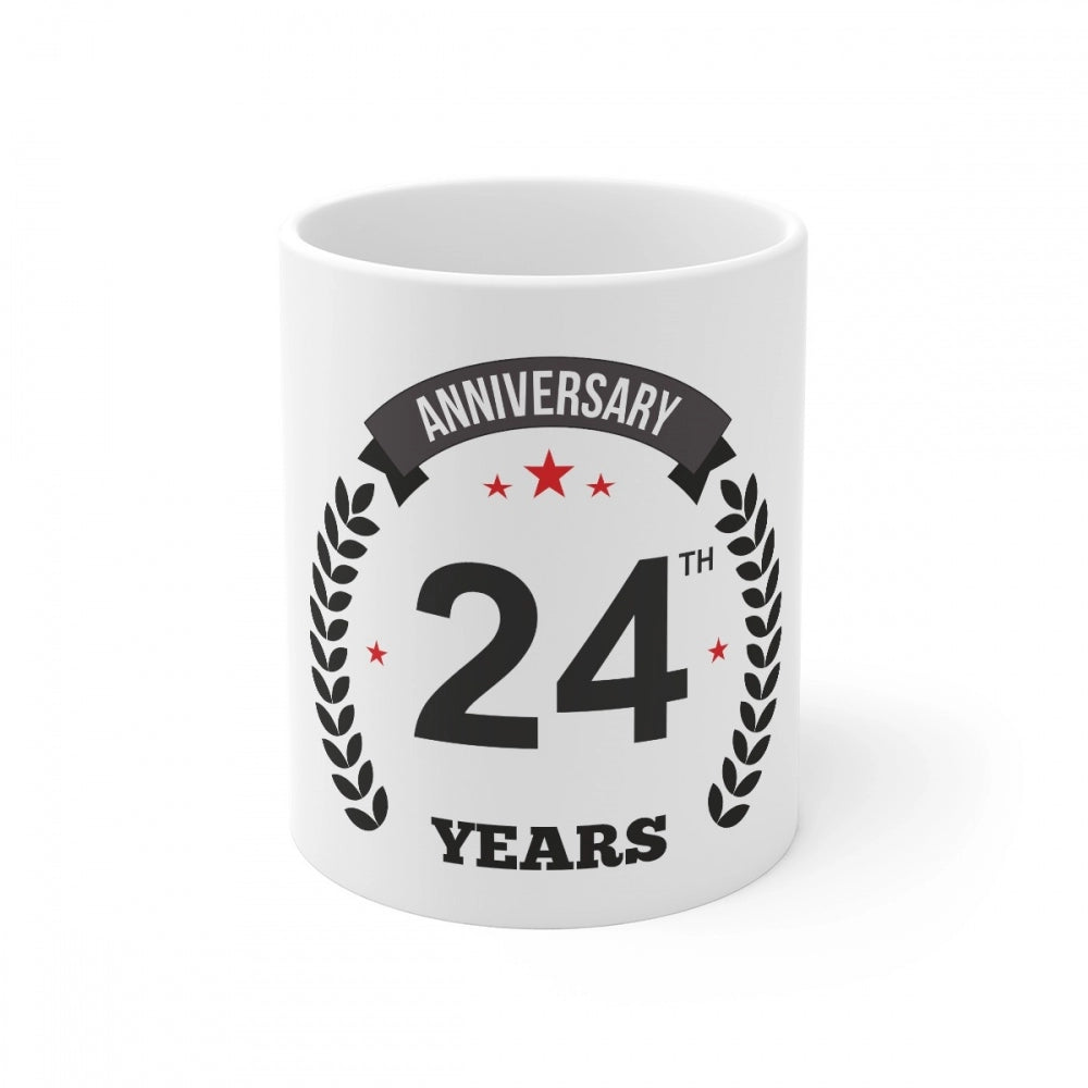 A white ceramic coffee mug with printed anniversary message and a red star graphic