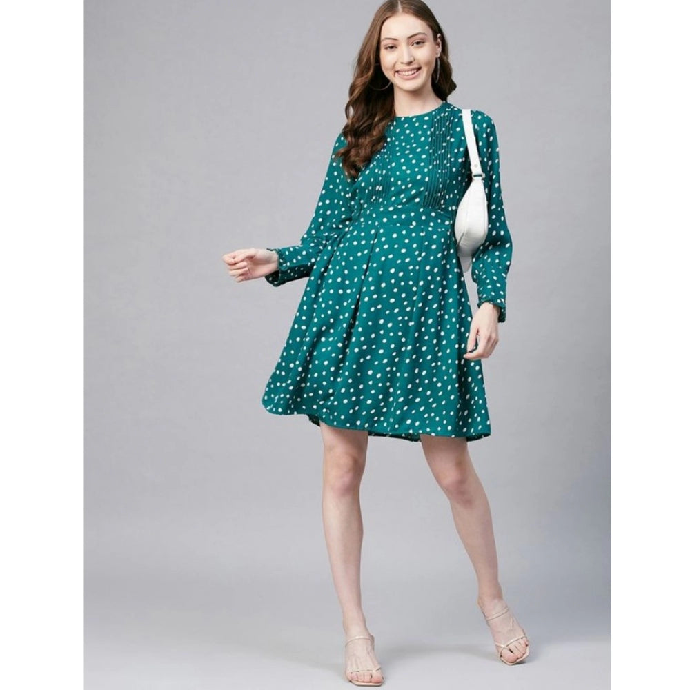 A woman in a green and white polka dot long sleeves dress with a handbag