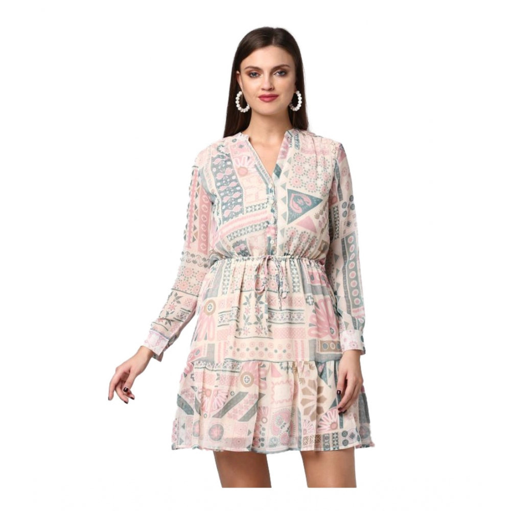 A woman in a light pink, off white, patterned long sleeved dress with designs above the knee
