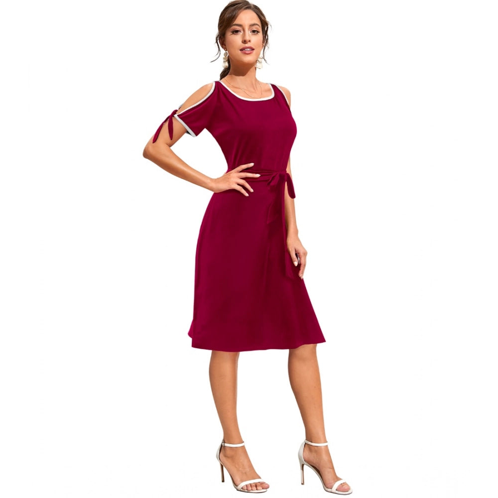 A woman wears a maroon sleeveless dress with a round neck