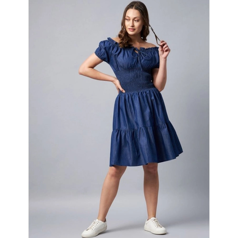 A woman in a blue denim off-shoulder short sleeve dress