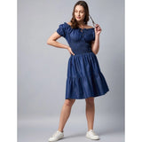A woman in a blue denim off-shoulder short sleeve dress