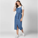 A person standing in a blue sleeveless round neck denim dress