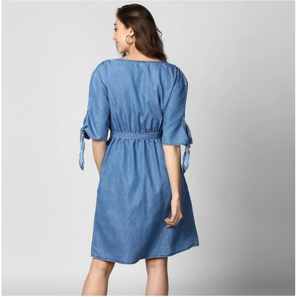 A woman in a light blue denim v-neck tie up dress