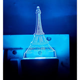 This is a photo of two images, the top one appears to be a night lamp with an Eiffel Tower design, featuring blue lighting. The bottom one shows a real-life object that resembles the same design but in the context of a plugged-in electronic device or appliance. It has a vibrant blue light and is designed with an Eiffel Tower motif on top