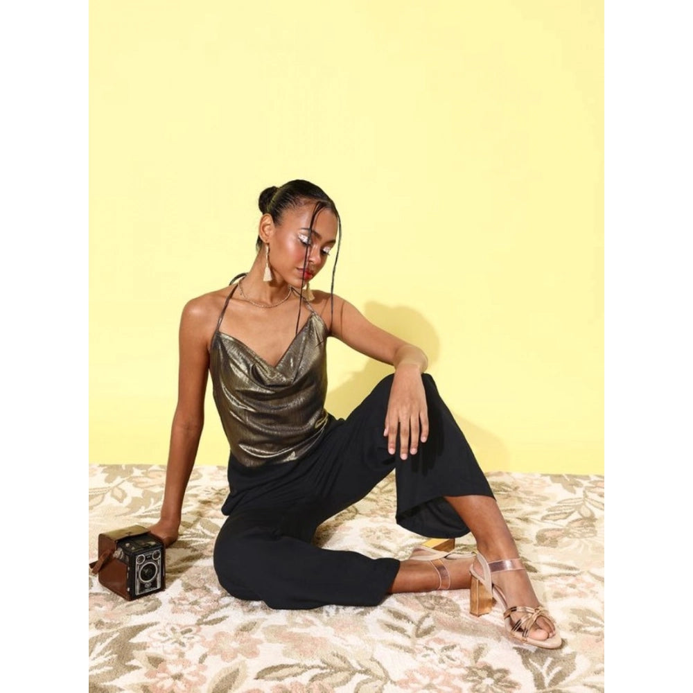 Woman in gold embellished polyester sleeveless jumpsuit posing with yellow background and camera