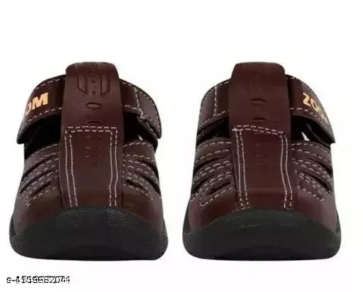 Brown synthetic leather casual sandals for kids, featuring Velcro fastening and PVC sole. Comfortable and trendy unisex pair from Kick Up, designed for flexibility and sturdy grip. Ideal for ages 9 months to 5 years