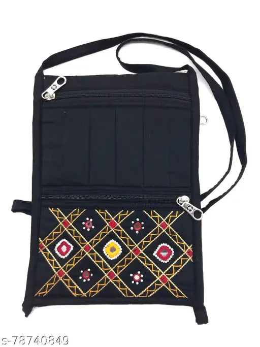 Black fabric sling handbag with colorful cross stitch detailing, zippered top, multiple card slots