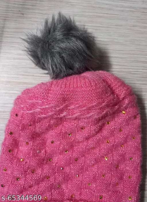 Pink knit cap with fur inside, pompom top, embellishments on front