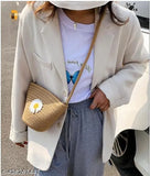 Tan jute sling bag with silver metal hardware and small floral embroidery detail, suitable for holding makeup or personal items
