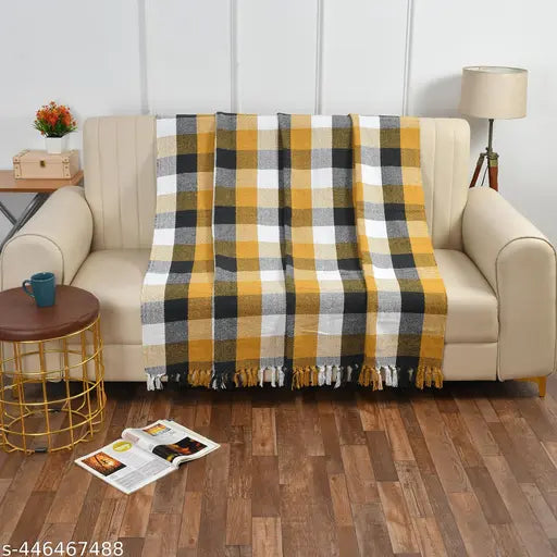 A plaid pattern throw blanket on a couch, single layer, suitable for bed, couch, and chair use