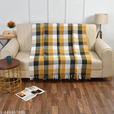 A plaid pattern throw blanket on a couch, single layer, suitable for bed, couch, and chair use