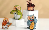 Colorful glass owls playing musical instruments as home décor or gifts