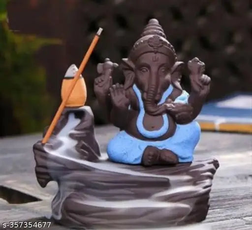 A chocolate figurine of Lord Ganesha, with blue fabric clothing and a small fishing rod accessory