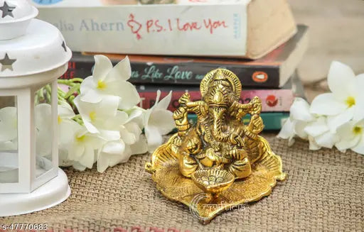 Golden oxide metal Lord Ganesh figurine on leaf with diya (11x9.5x7 cm), ideal for puja or home decor, symbolizing positive energy and good start, popular religious gift from India