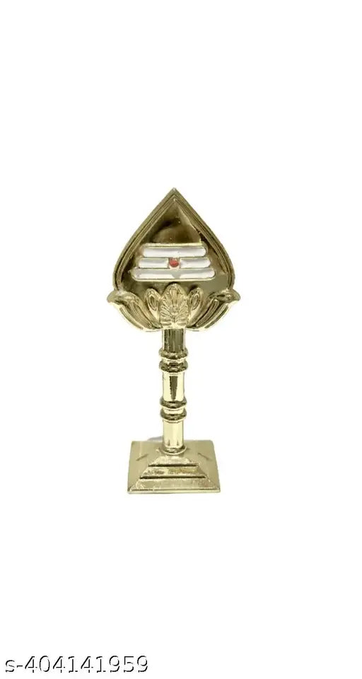 A gold metal Om with a glass top, placed on a temple or car dashboard